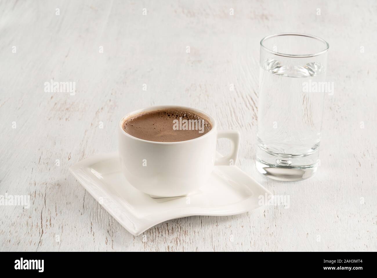 Le café turc servi avec un verre d'eau sur une table en bois Banque D'Images
