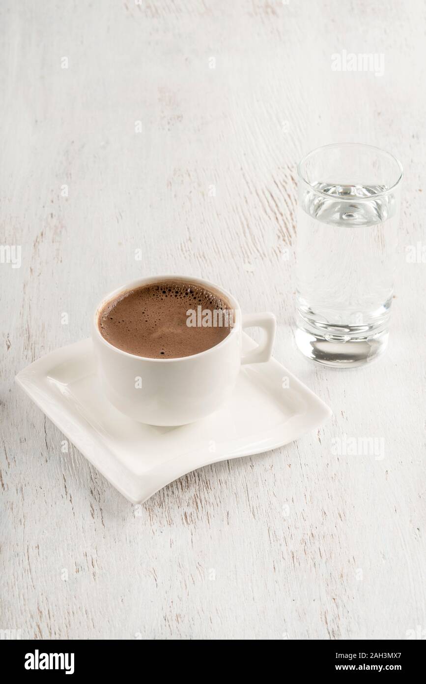 Le café turc servi avec un verre d'eau sur une table en bois Banque D'Images