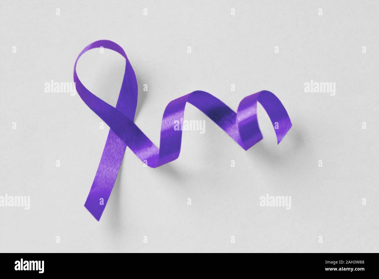 Ruban violet sur fond blanc - Concept de la violence domestique ; sensibilisation à la maladie d'Alzheimer, cancer du pancréas, sensibilisation à l'épilepsie et la maladie de Hodgkin Banque D'Images