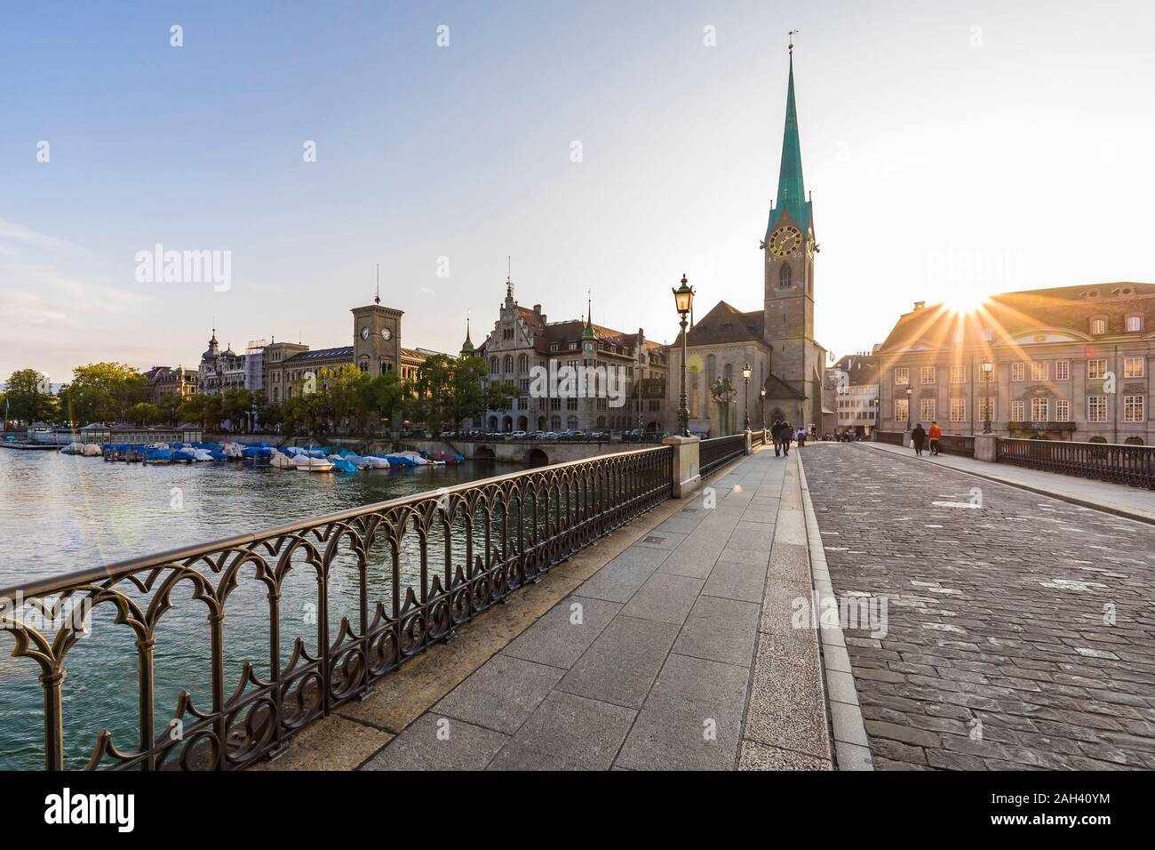 La Suisse, Canton de Zurich, Zurich, Munsterbrucke bridge au coucher du soleil avec en arrière-plan l'église Fraumunster Banque D'Images