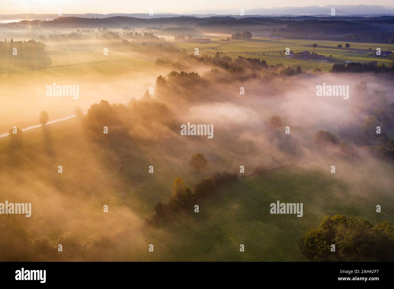 Allemagne, Bavière, Geretsried, vue aérienne de campagne enveloppée de brouillard au lever du soleil Banque D'Images
