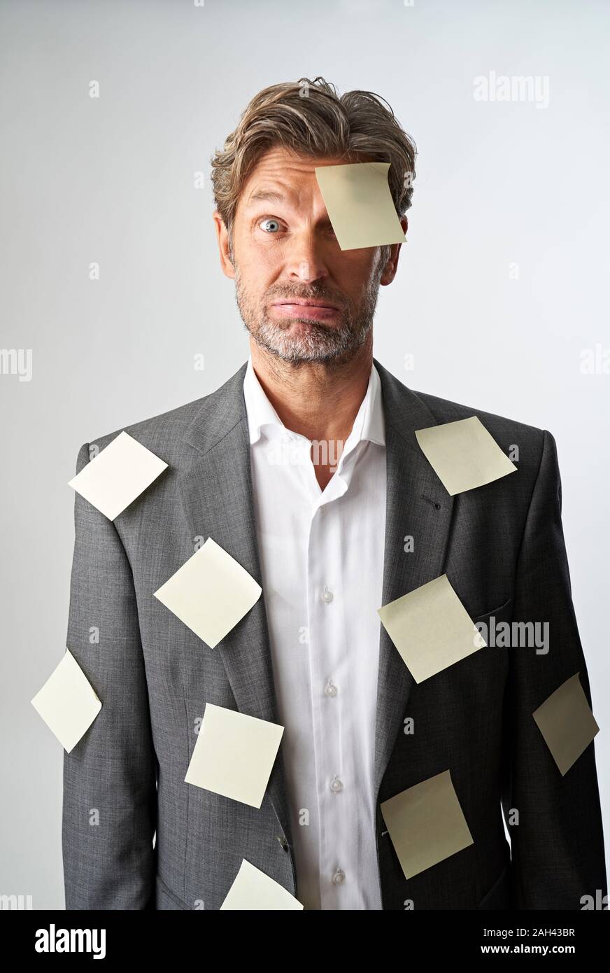 Portrait d'homme sans défense avec remarque stucking documents sur son front et son costume coat Banque D'Images