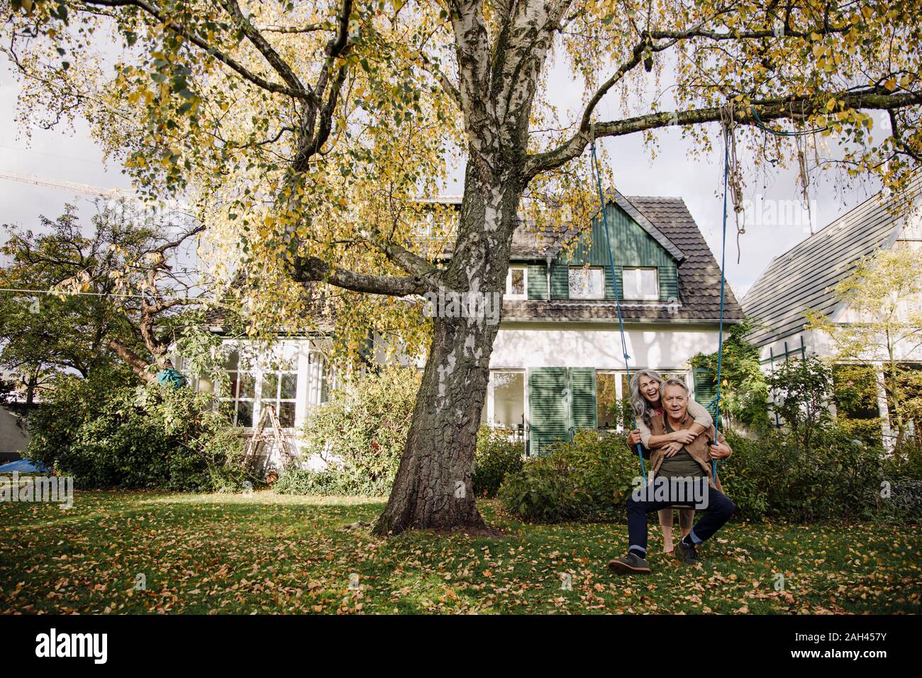 Happy woman embracing man sur une balançoire dans le jardin Banque D'Images