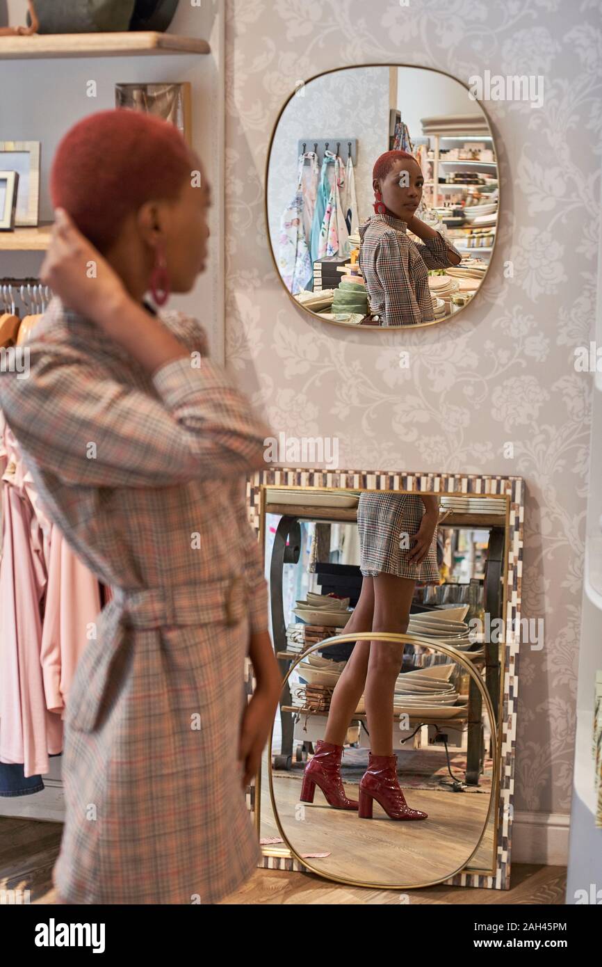 Femme avec une coupe de cheveux colorés reflètent son contrôle sur le miroir Banque D'Images