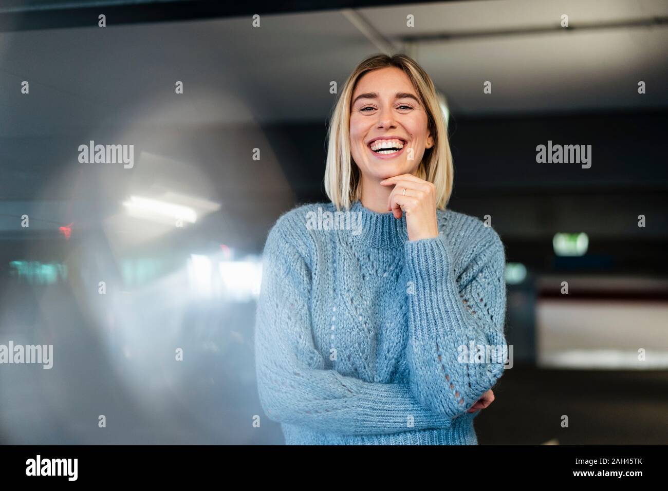 Portrait d'une jeune femme riait dans un parking couvert Banque D'Images