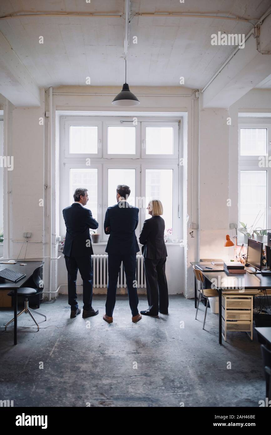 Les gens d'affaires debout à la fenêtre in office Banque D'Images