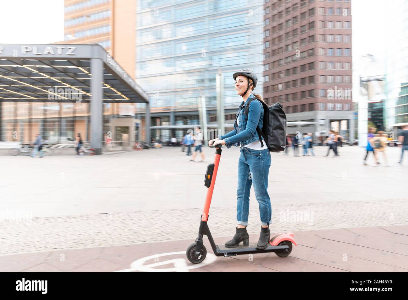 Happy woman riding e-scooter dans la ville, Berlin, Allemagne, Berlin, Allemagne Banque D'Images
