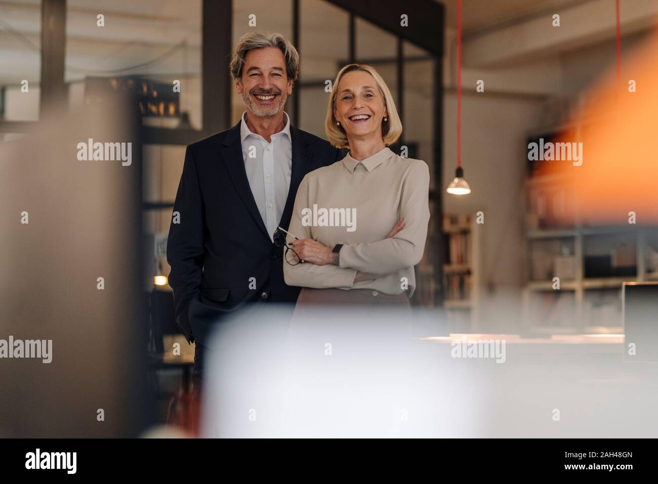 Le Portrait of smiling businessman and businesswoman in office Banque D'Images