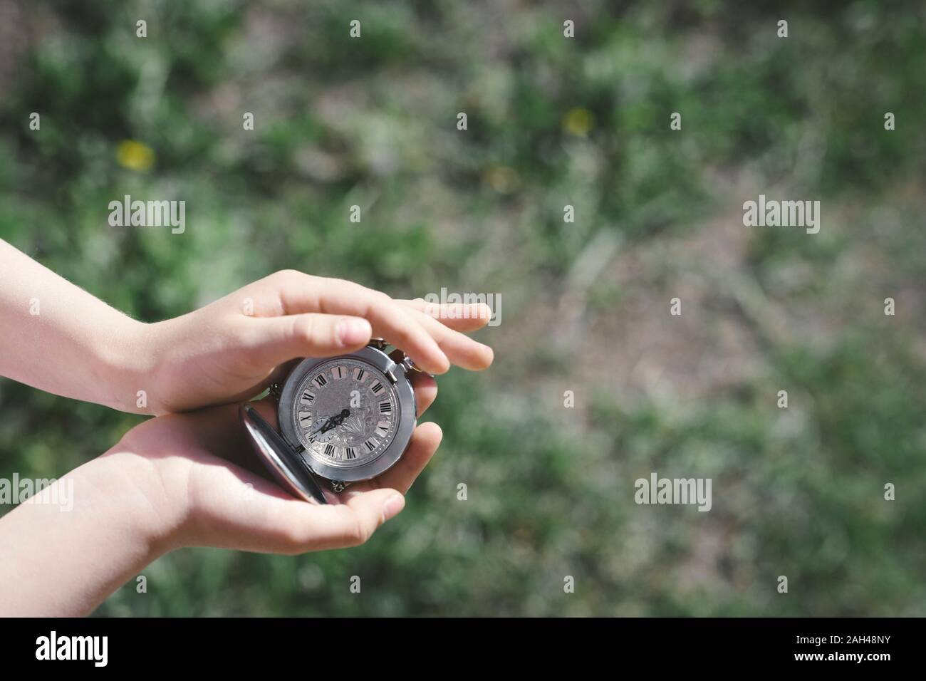 Girl's hands holding silver pocket réveil, close-up Banque D'Images