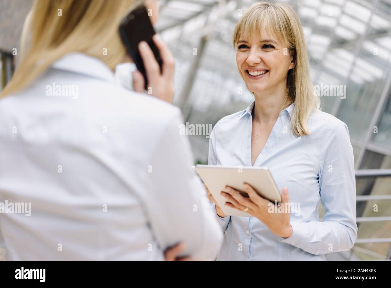 Portrait of young businesswoman with tablet smiling at office Banque D'Images