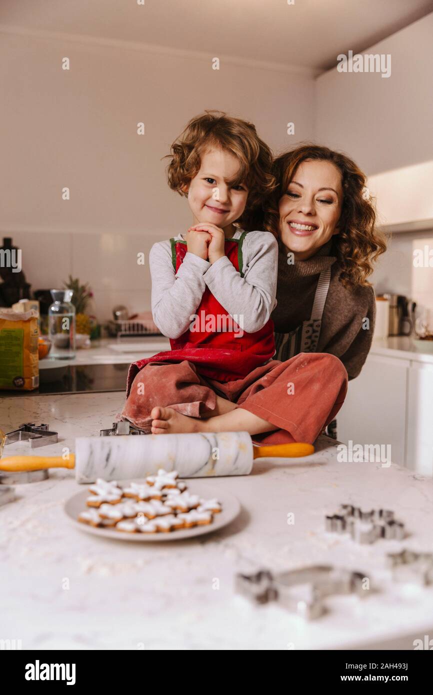 Portrait of happy mother and daughter with Christmas Cookies in kitchen Banque D'Images