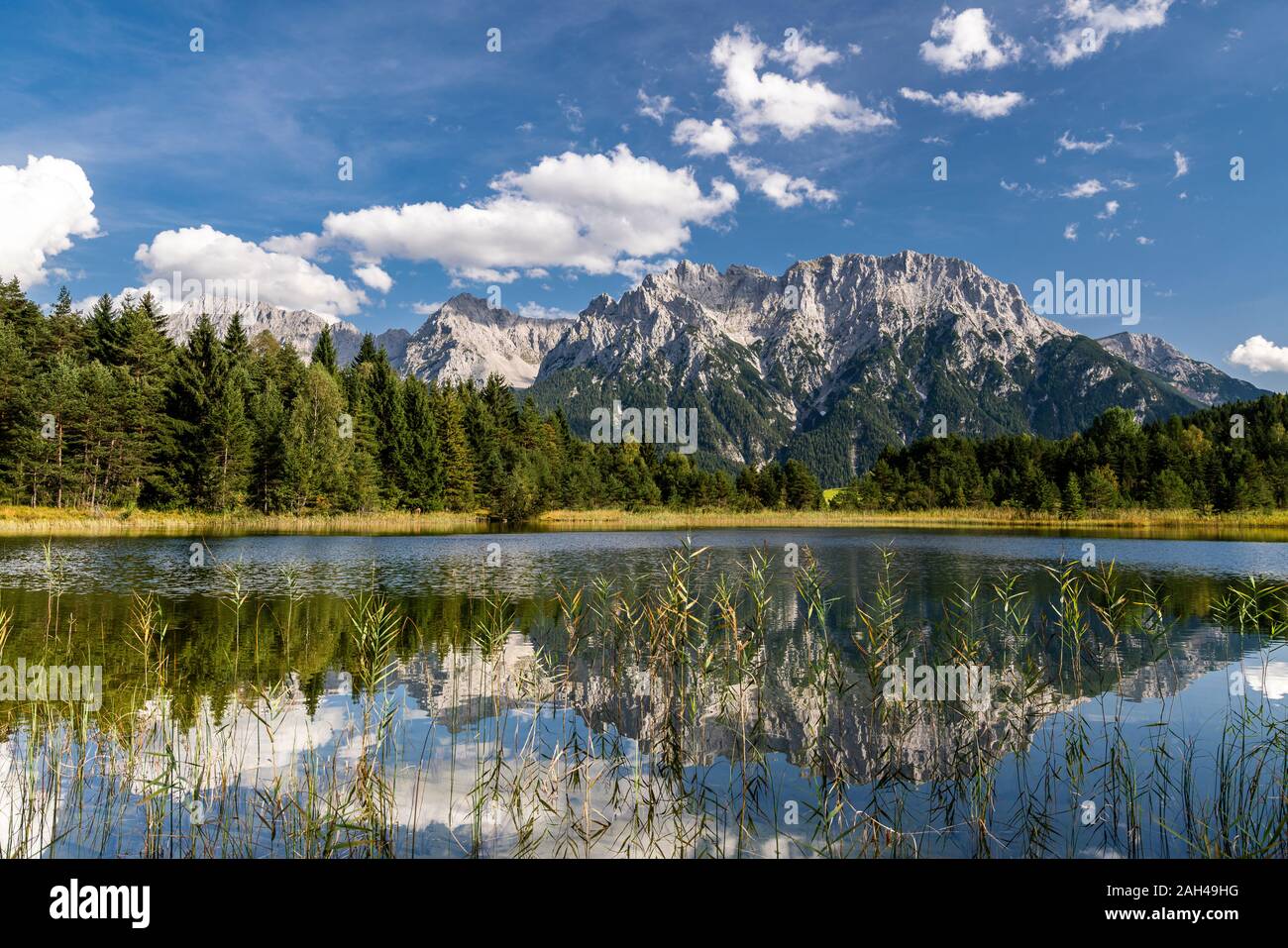 Autriche, Tyrol, vue panoramique sur les montagnes de Wetterstein reflétant le lac Weisssee et forêt environnante Banque D'Images