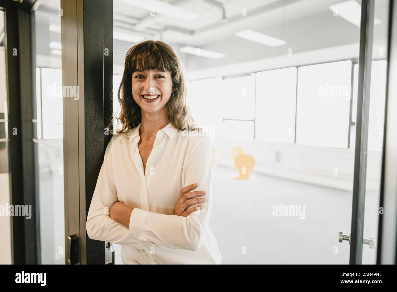 Smiling businesswoman standing dans une porte de bureau Banque D'Images