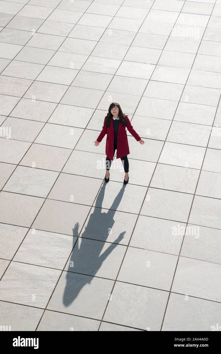 Vue de dessus de walking businesswoman standing moderne sur un sol en béton avec les bras ouverts Banque D'Images