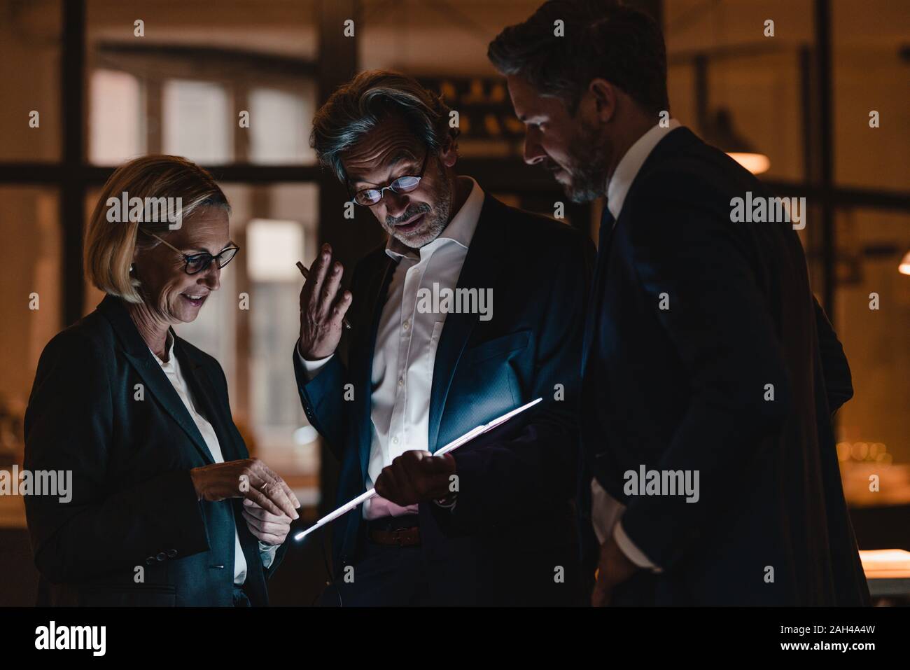 Les gens d'affaires avec shining tablet in office Banque D'Images
