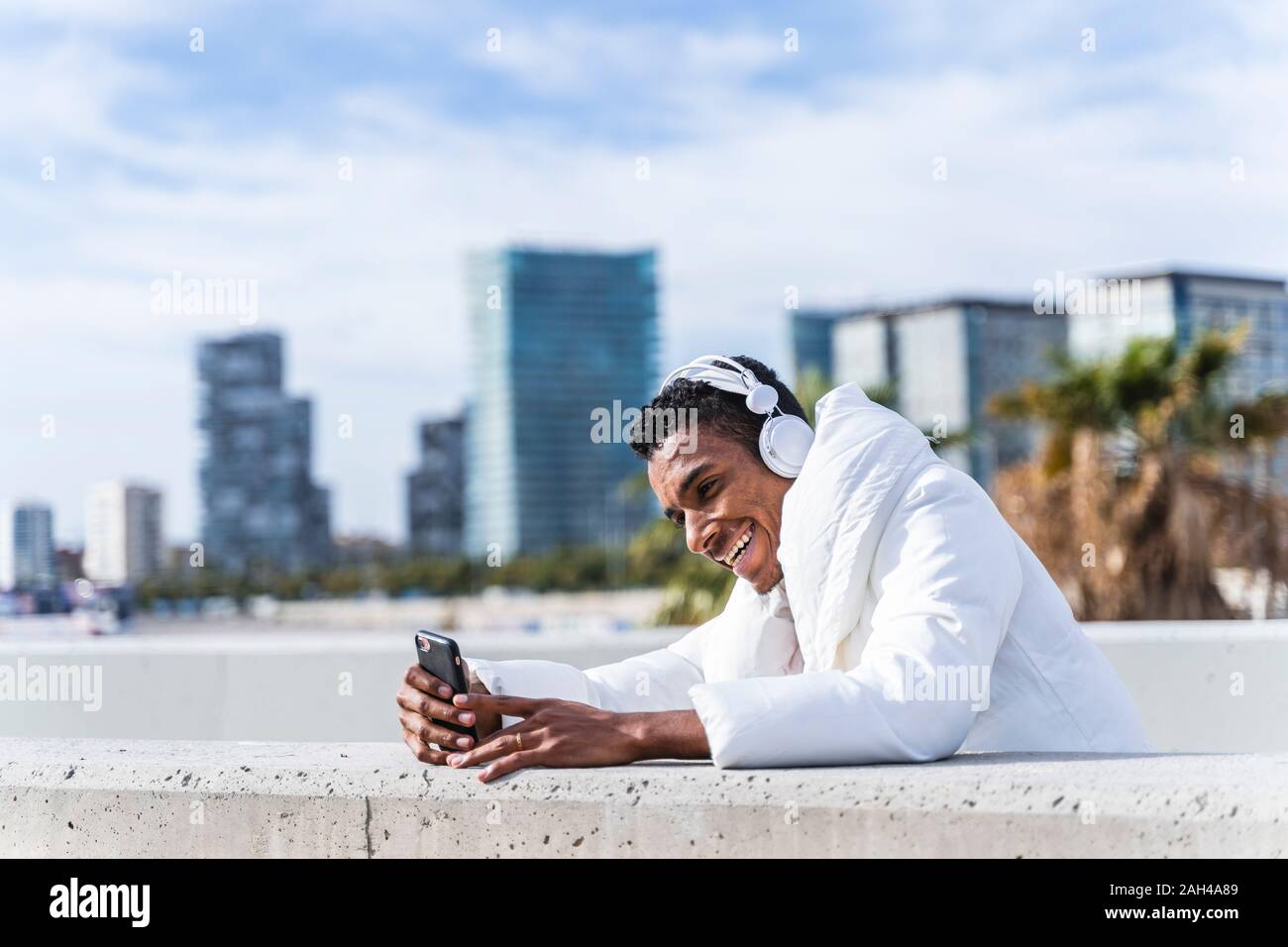Heureux jeune homme avec un casque et smartphone outdoors Banque D'Images