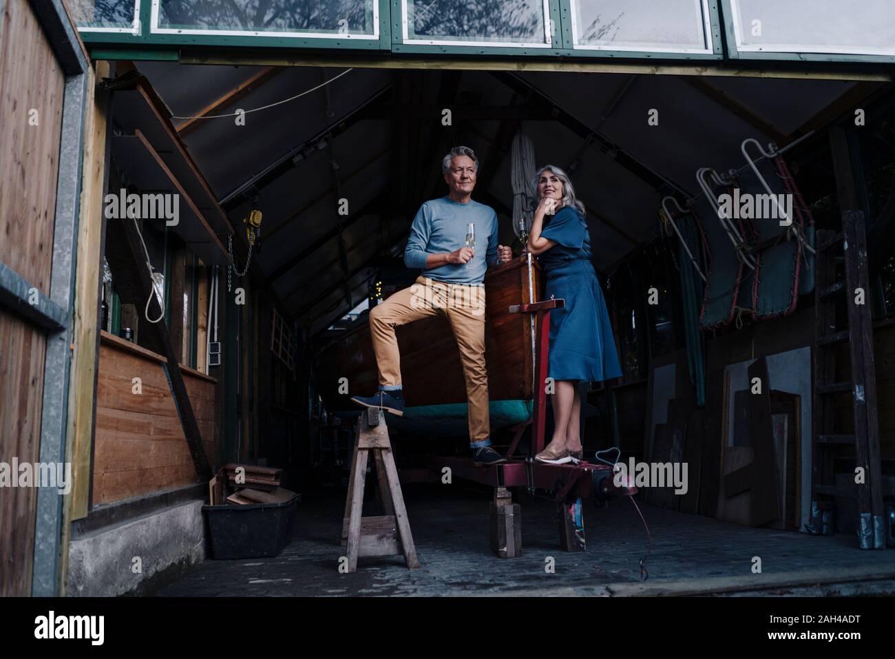 Couple dans un hangar à bateaux avec coupe de champagne Banque D'Images