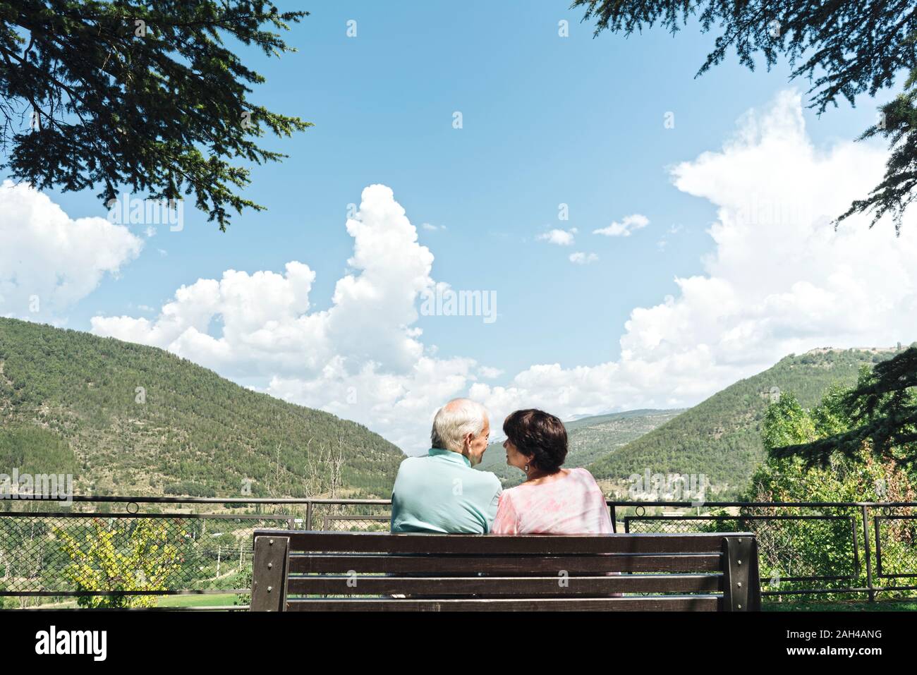 Vue arrière du couple assis sur un banc, regarder, Jaca, Espagne Banque D'Images