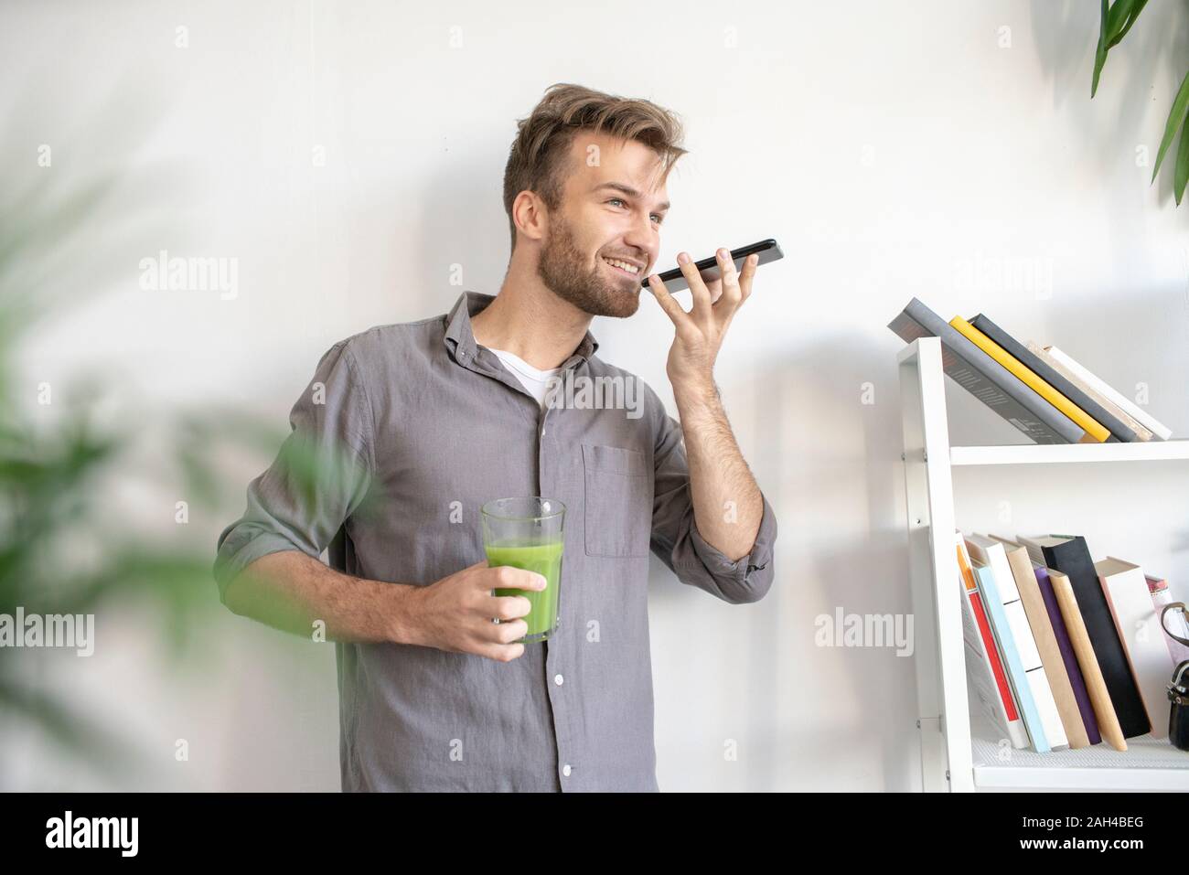 Smiling man using smartphone in office Banque D'Images