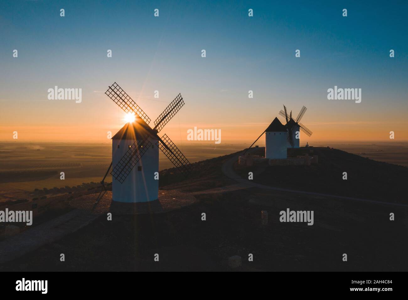 Espagne, province de Ciudad Real, Alcazar de San Juan, vieux moulins à vent debout sur la colline parlementaire au coucher du soleil Banque D'Images
