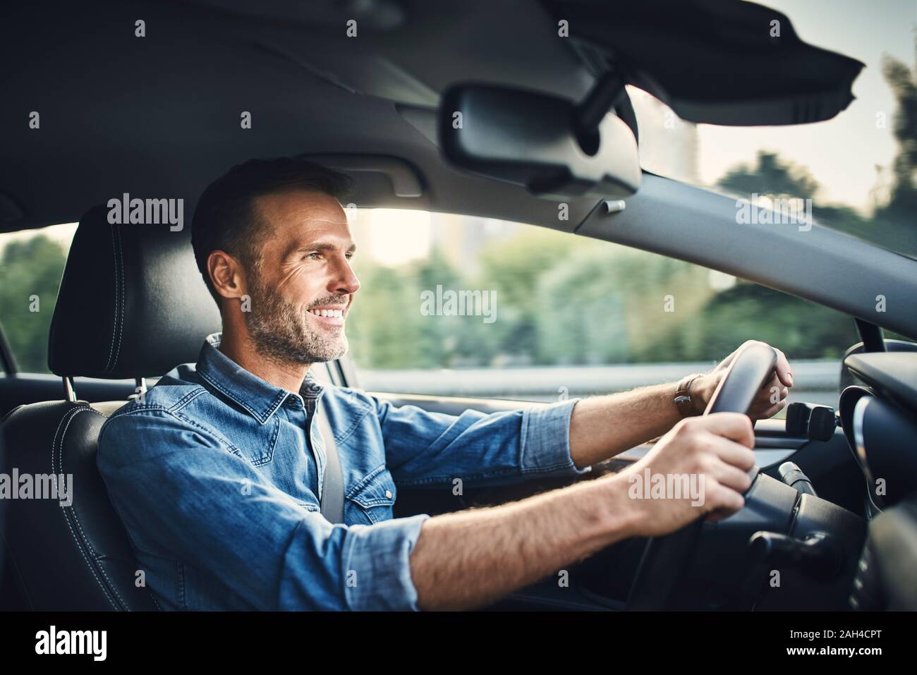 Handsome man driving a car Banque D'Images