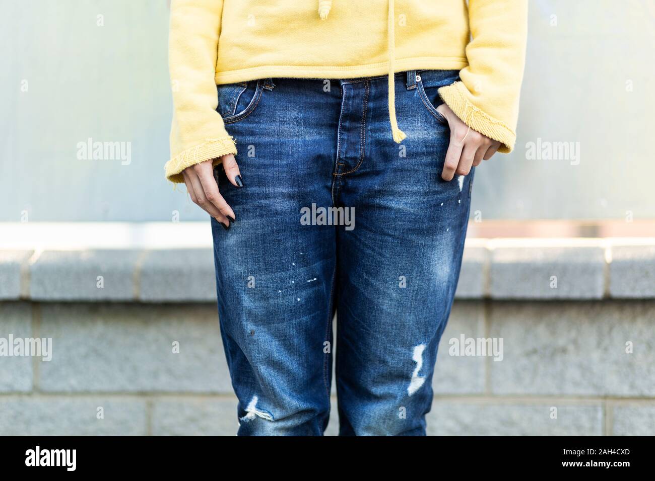 Jeune femme portant un jean bleu foncé ancien, vue partielle Banque D'Images