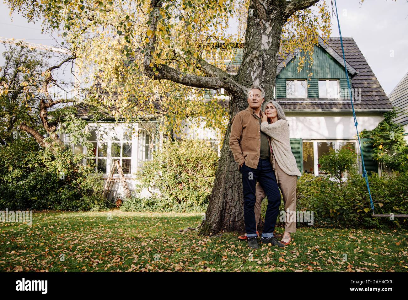 Senior couple in jardin de leur maison à l'automne Banque D'Images