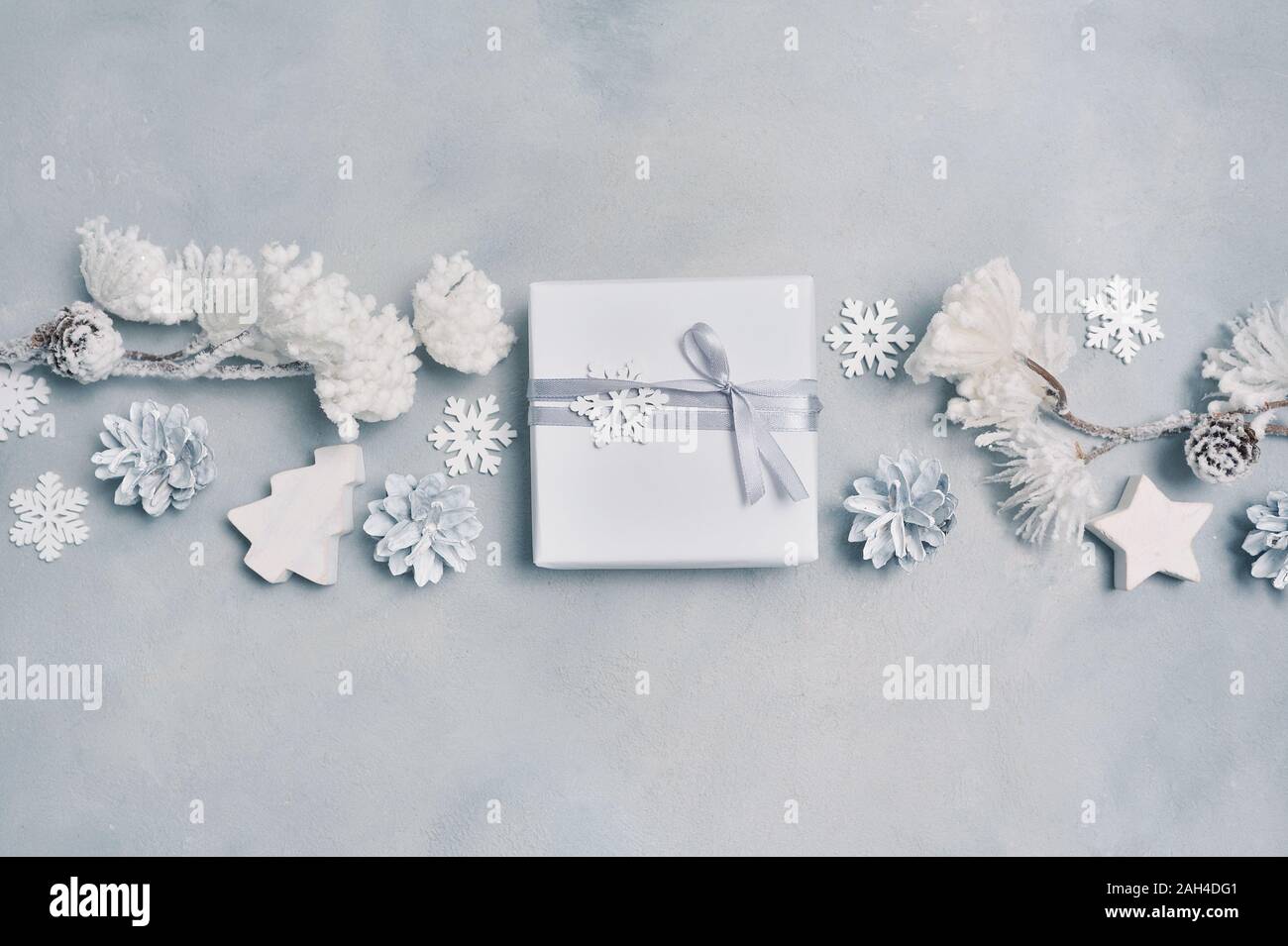La conception de la frontière une carte de vœux de Noël avec boîte-cadeau de Noël, des cônes, des flocons avec place pour votre texte. Décorations sur un fond en béton blanc Banque D'Images