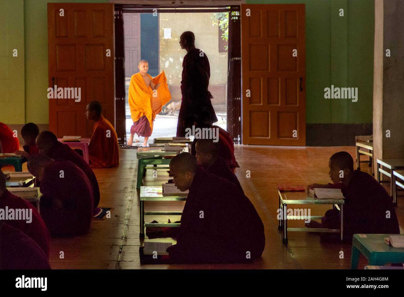 La lecture et l'étude des moines dans la salle de classe du monastère à Mandalay, Myanmar Banque D'Images