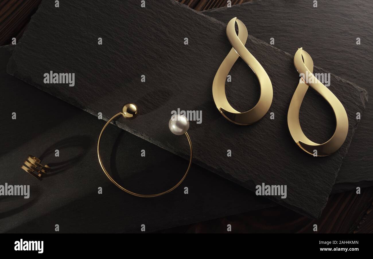 La lumière du soleil sur les accessoires d'or placés sur des plaques de pierre. Boucles d'oreilles, bague et bracelet de perles sur fond de pierre Banque D'Images
