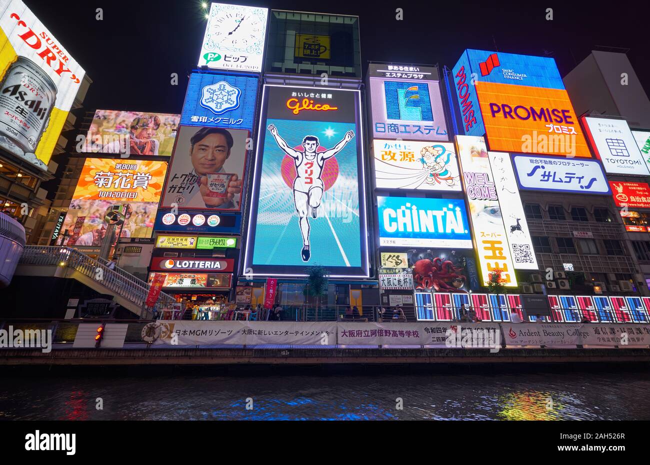 OSAKA, JAPON - 14 octobre 2019 : Les chambres lumineuses et les panneaux flashy le long du canal Dotonbori avec le symbole de la ville, l'homme courant Glico à nig Banque D'Images