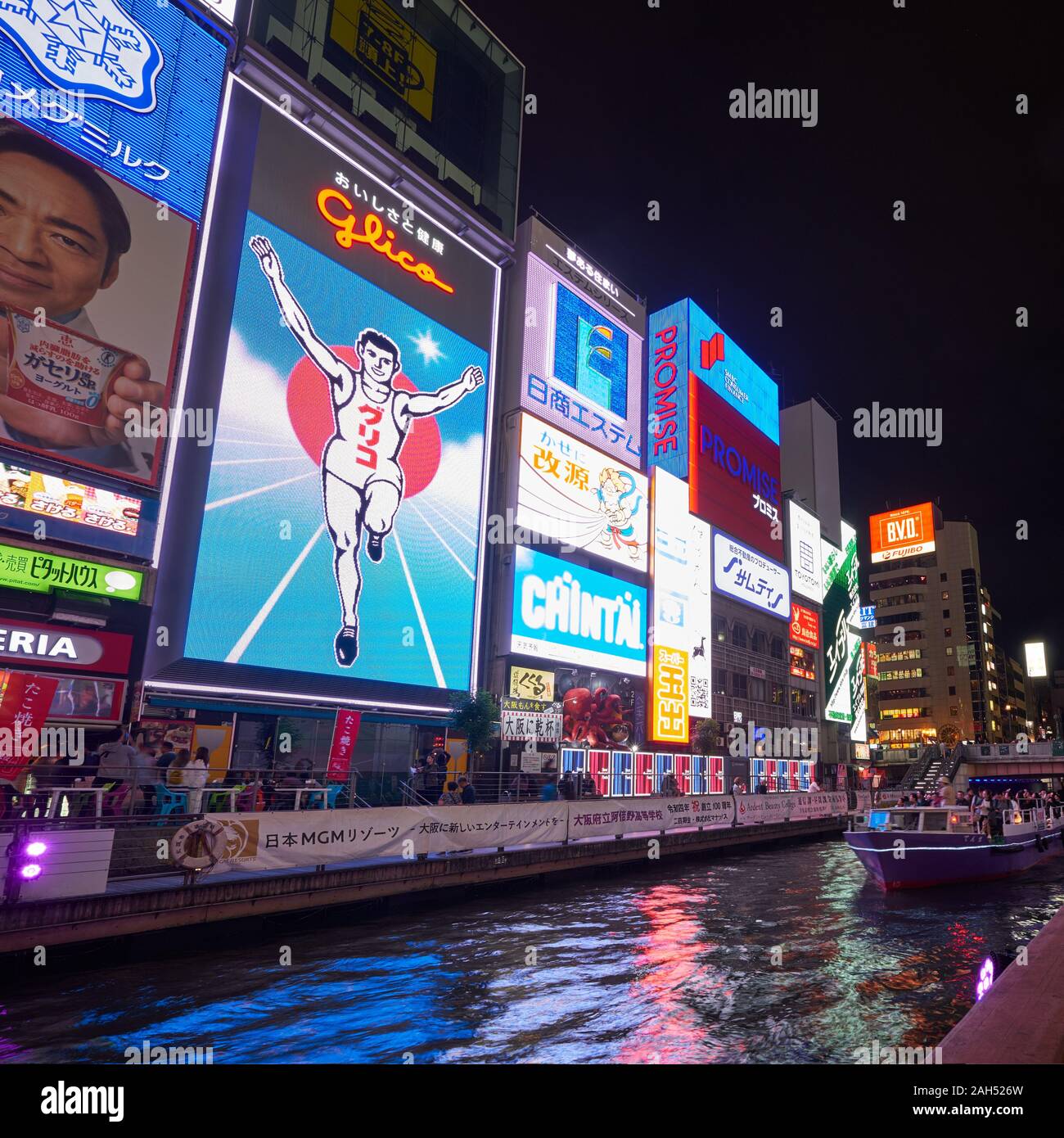 OSAKA, JAPON - 14 octobre 2019 : Les chambres lumineuses et les panneaux flashy le long du canal Dotonbori avec le symbole de la ville, l'homme courant Glico à nig Banque D'Images