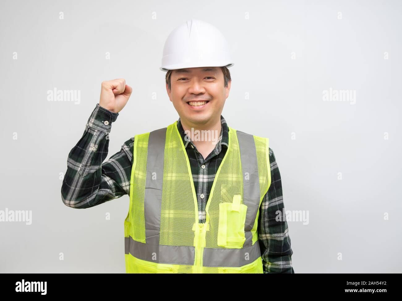 Homme d'âge moyen de l'Asie dans un gilet vert clair et blanc chapeau de sécurité. Banque D'Images