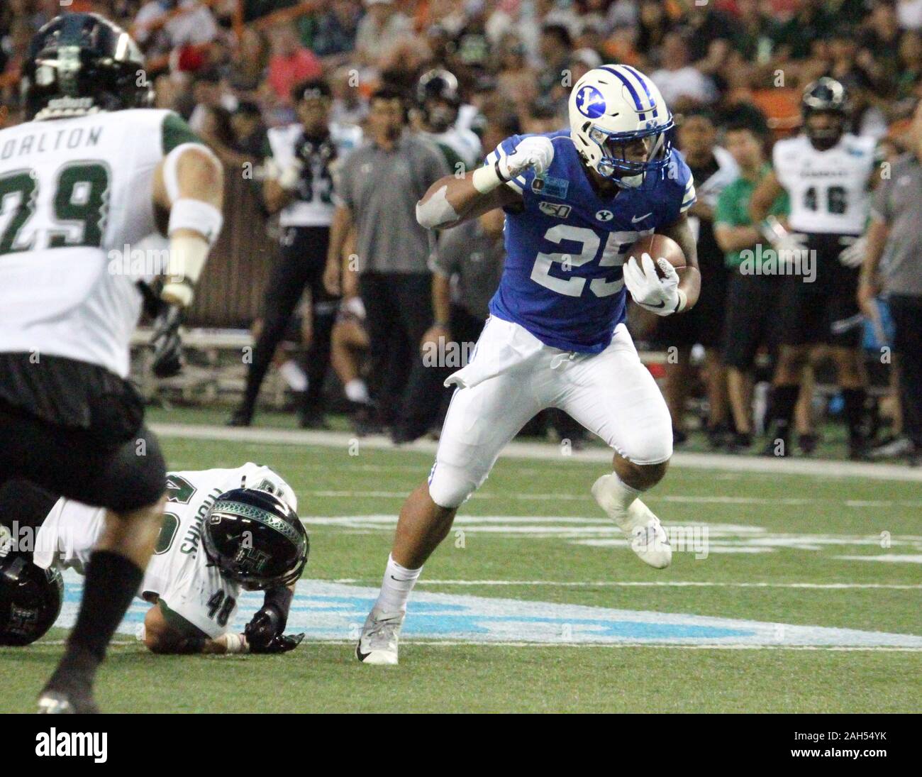 Honolulu, Hawaii, USA. Le 24 décembre, 2019. 24 décembre 2019 - les Cougars de Brigham Young de secondeur Tyler Allgeier (25) passe devant Hawaii Rainbow Warriors joueur défensif Derek Thomas (48) au cours d'une partie à la SoFi Hawaii Bowl entre les Cougars de Brigham Young et de l'Indiana Rainbow Warriors au shérif Stan Center à Honolulu, HI - Michael Sullivan/CSM Crédit : Cal Sport Media/Alamy Live News Banque D'Images