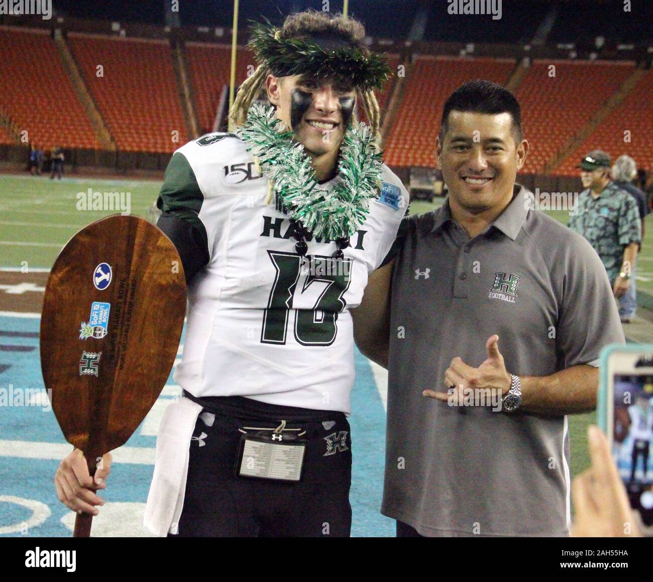 Honolulu, Hawaii, USA. Le 24 décembre, 2019. 24 décembre 2019 - Hawaii Rainbow Warriors quarterback Cole McDonald (13) et l'entraîneur Craig Stuzmann poser après le SoFi Hawaii Bowl entre les Cougars de Brigham Young et de l'Indiana Rainbow Warriors au shérif Stan Center à Honolulu, HI - Michael Sullivan/CSM. Credit : Cal Sport Media/Alamy Live News Banque D'Images
