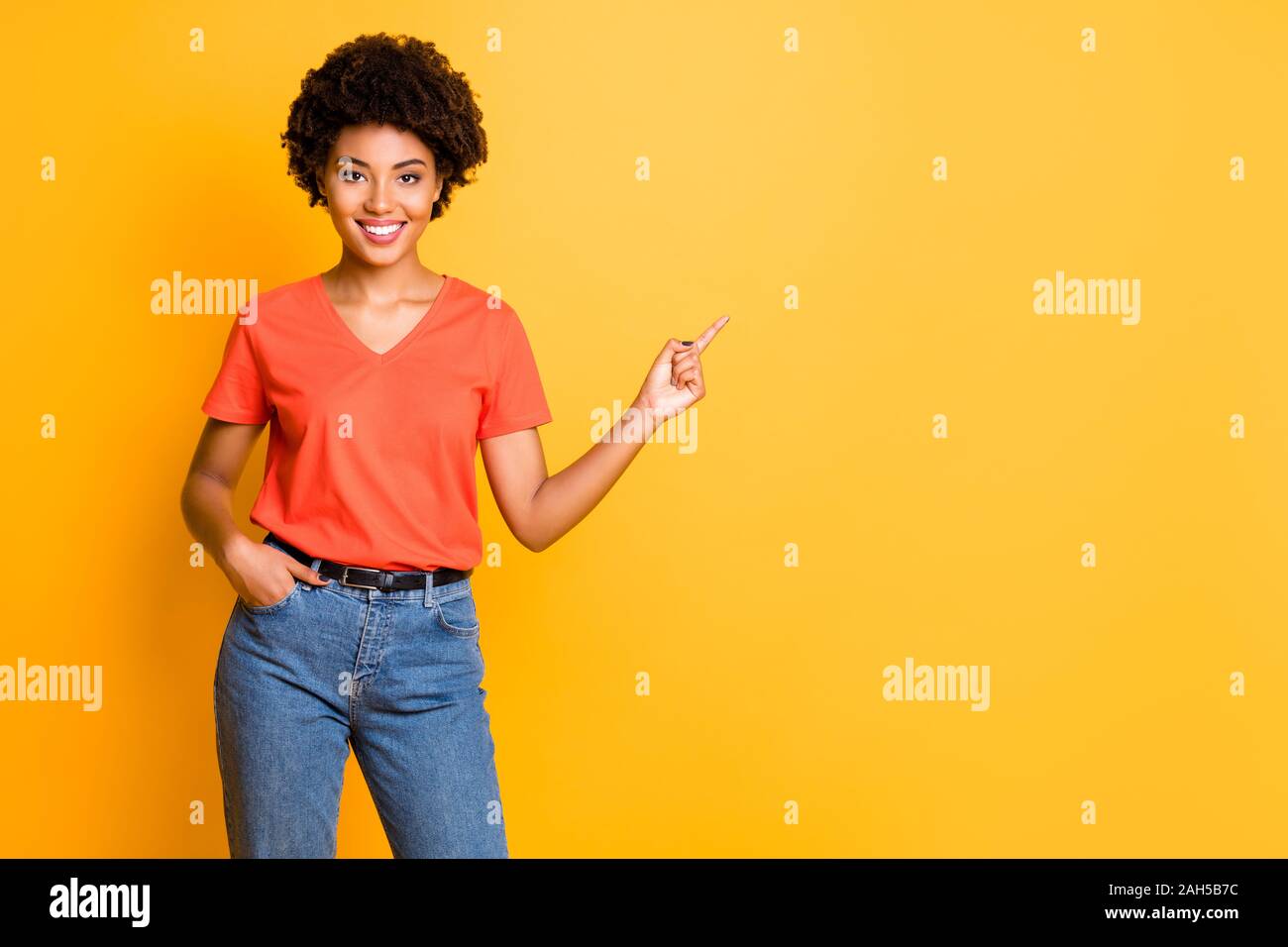 Copyspace photo de joli mignon fascinant assez confiant amie, noir-américain pointant à l'espace à remplir portant des T-shirt denim whi Banque D'Images