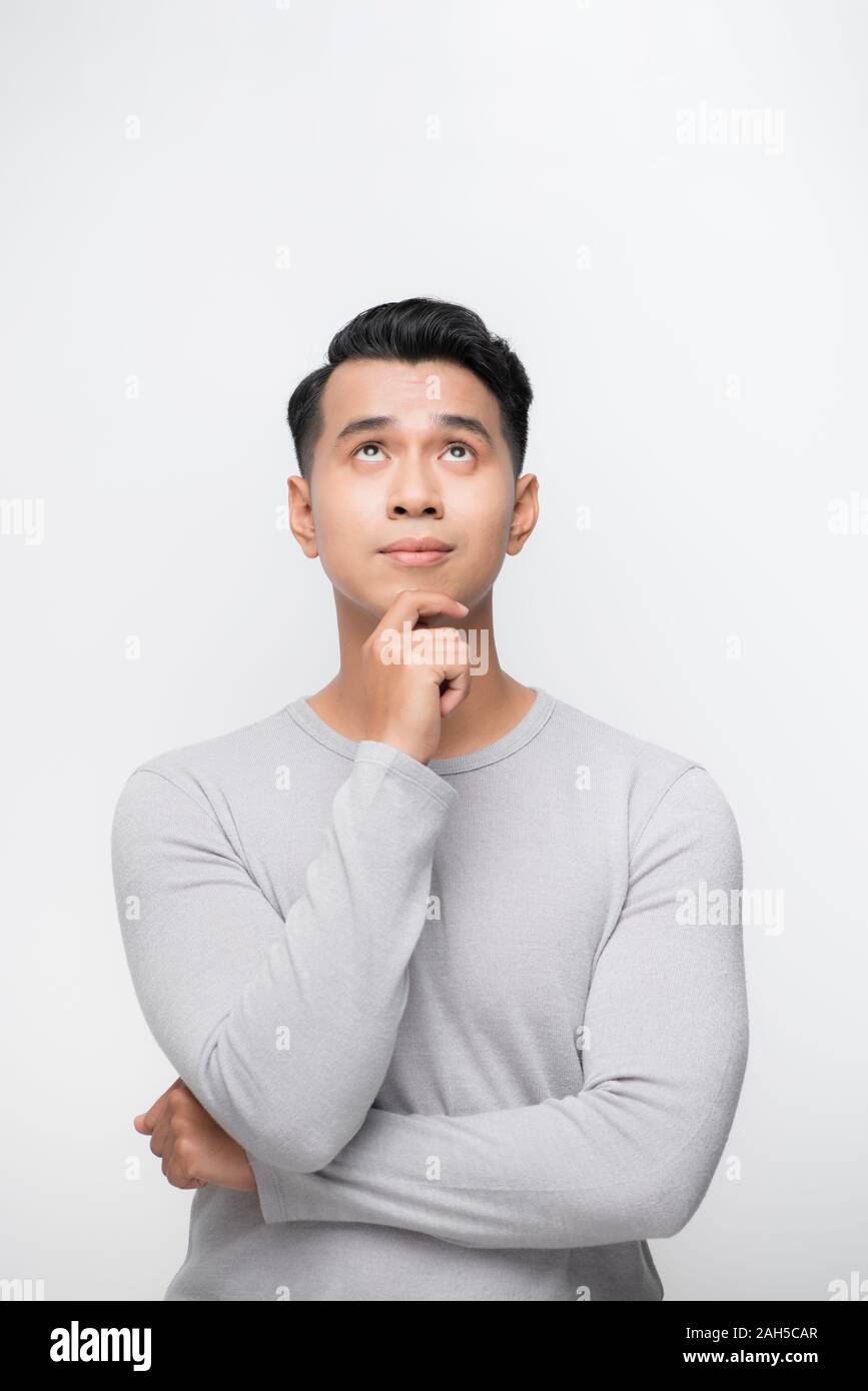 Un portrait d'un jeune homme asiatique jusqu'à la pensée plus isolé sur fond blanc Banque D'Images