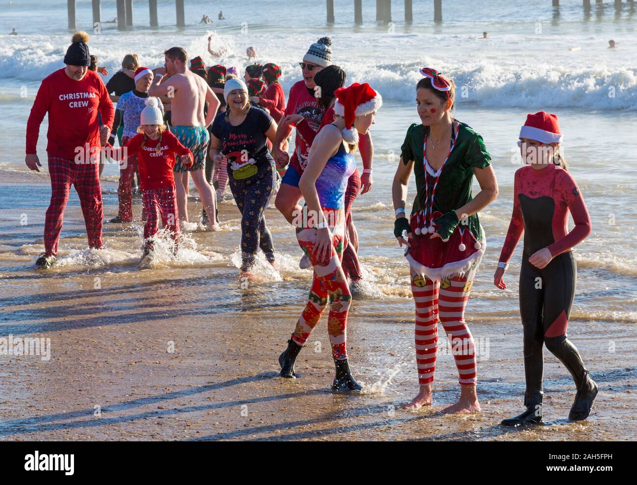 Boscombe, Bournemouth, Dorset, Royaume-Uni. Jour de Noël 25 décembre 2019. Les courageux volontaires plongent dans la mer pour nager ou se baigner lors d'une belle journée ensoleillée, pour l'association caritative annuelle White Christmas DIP, la plus grande trempette de Noël du Royaume-Uni, vêtue de costumes habillés de fantaisie et amassant de l'argent pour Macmillan Caring local à Christchurch, Une unité de soins palliatifs spécialisés pour les patients de la communauté locale. Plus d'un millier prennent part à l'événement qui est devenu une tradition populaire pour beaucoup avant leur déjeuner de Noël. Crédit : Carolyn Jenkins/Alay Live News Banque D'Images