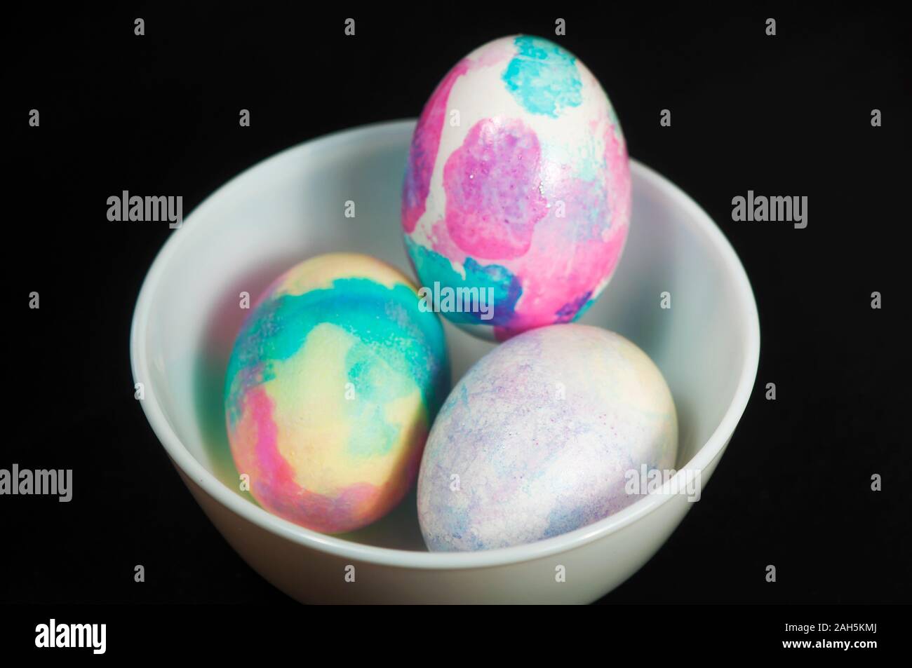 Les œufs de Pâques colorés fond noir dans un petit bol pour la maison de vacances. Banque D'Images
