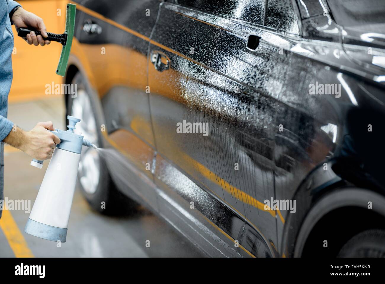 Location service worker les projections d'eau sur la carrosserie, le tremper avant film anti-gravillon s'appliquent au détaillant de service du véhicule Banque D'Images