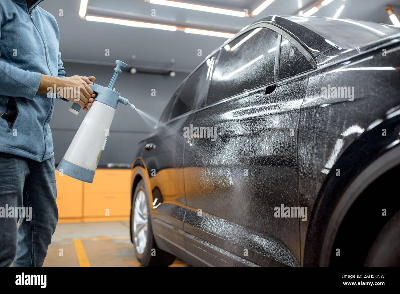 Location service worker les projections d'eau sur la carrosserie, le tremper avant film anti-gravillon s'appliquent au détaillant de service du véhicule Banque D'Images