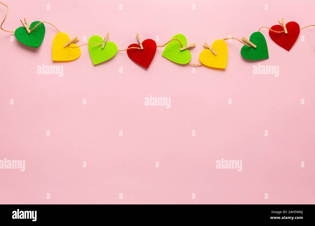 Coeurs colorés répartis sur le clothespin avec fond rose pastel. La Saint-Valentin, fête des mères, cartes de souhaits d'anniversaire, fête, invitation, concep Banque D'Images