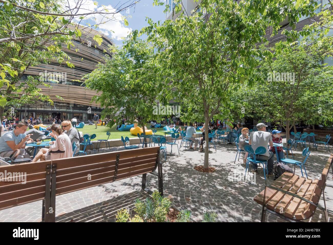 Les gens pique-nique dans le parc de l'échange de nouvelles capacités dans Darling Square, Sydney, Australie, conçu par l'entreprise d'architecture japonais Kengo Kuma Banque D'Images