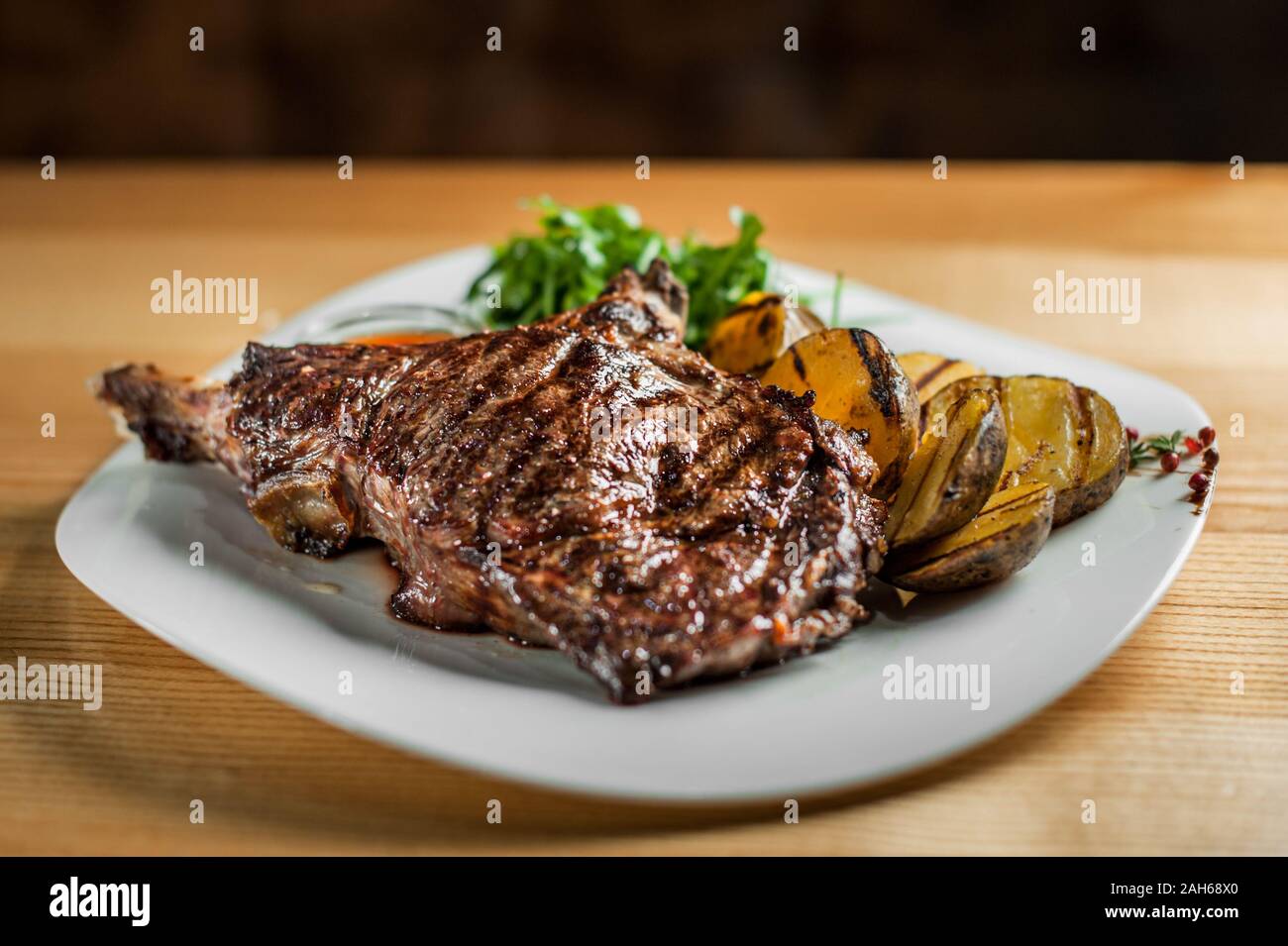 Un steak juteux, délicieux, cuits sur le grill, se trouve avec légumes et sauce sur une assiette blanche. Banque D'Images