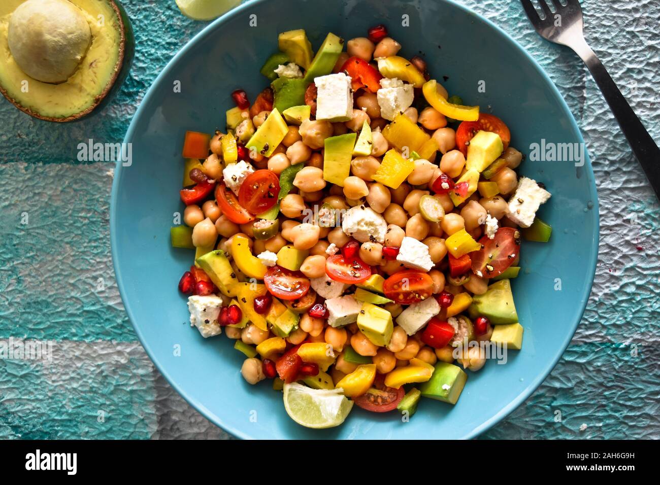 Vue de dessus de la salade de pois chiches avec avocat, fromage feta, tomates cerises, oignons et fines herbes, cuisine méditerranéenne, saladier, aliments colorés Banque D'Images