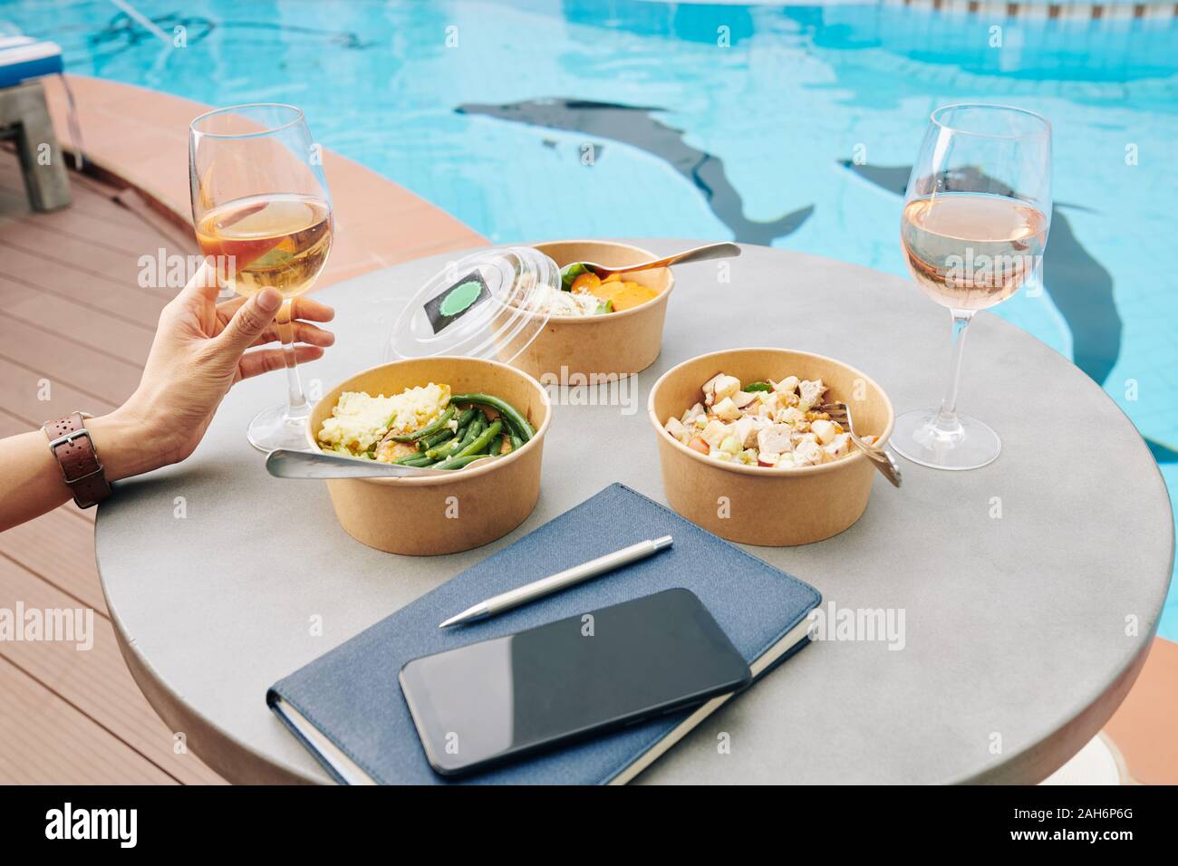 Trois des plats sains emballées dans des boîtes en carton sur cafe de table avec verre de vin rose Banque D'Images