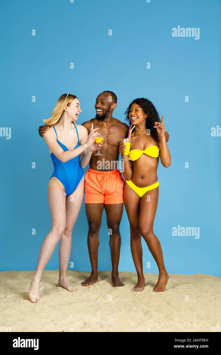 Des moments heureux. Heureux les jeunes amis se reposer et s'amuser sur fond studio bleu. Concept d'émotions humaines, expression du visage, vacances d'été ou de fin de semaine. Chill, été, mer, océan. Banque D'Images