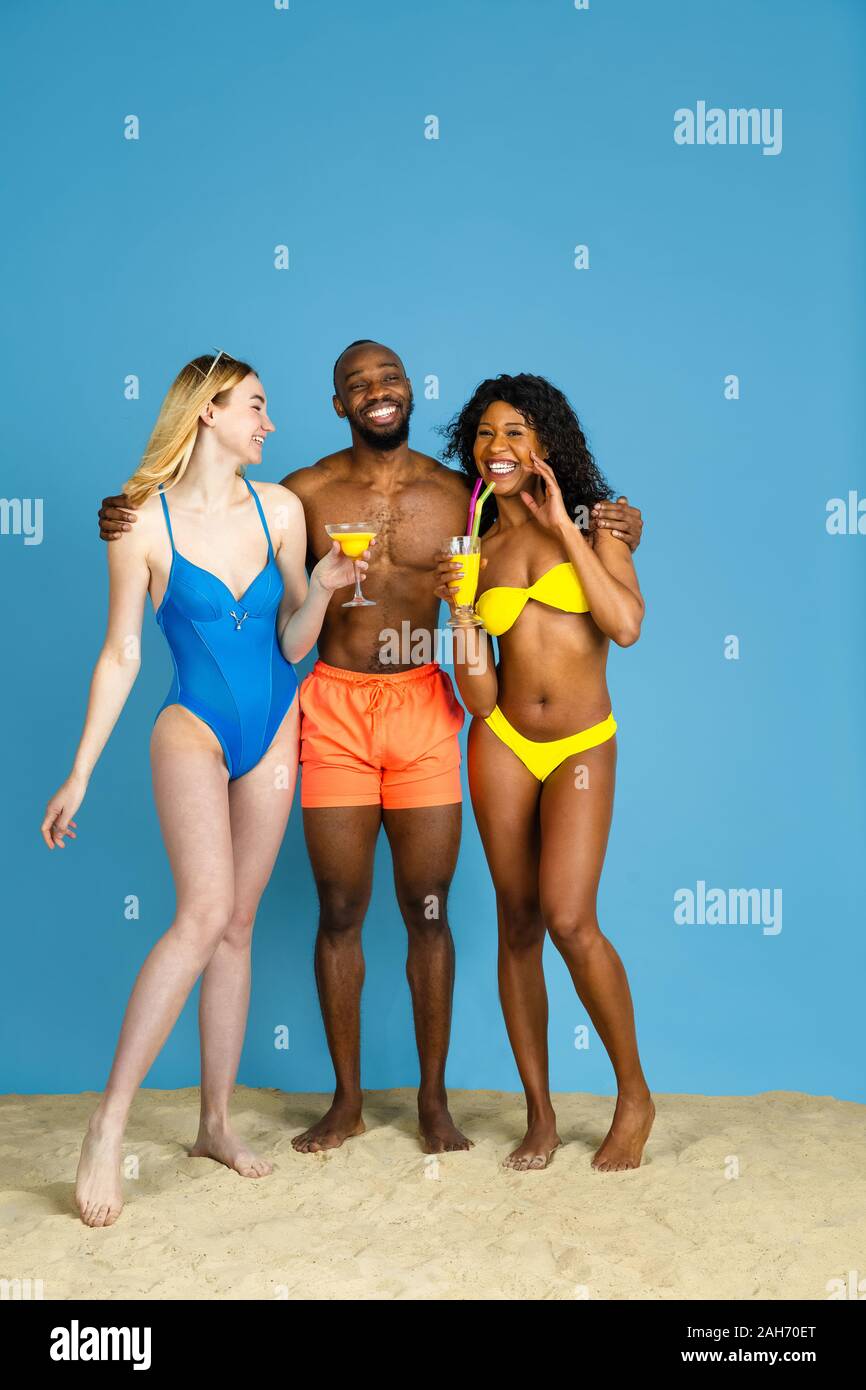 Des moments heureux. Heureux les jeunes amis se reposer et s'amuser sur fond studio bleu. Concept d'émotions humaines, expression du visage, vacances d'été ou de fin de semaine. Chill, été, mer, océan. Banque D'Images