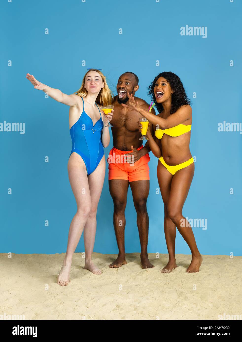 Des moments heureux. Heureux les jeunes amis se reposer et s'amuser sur fond studio bleu. Concept d'émotions humaines, expression du visage, vacances d'été ou de fin de semaine. Chill, été, mer, océan. Banque D'Images