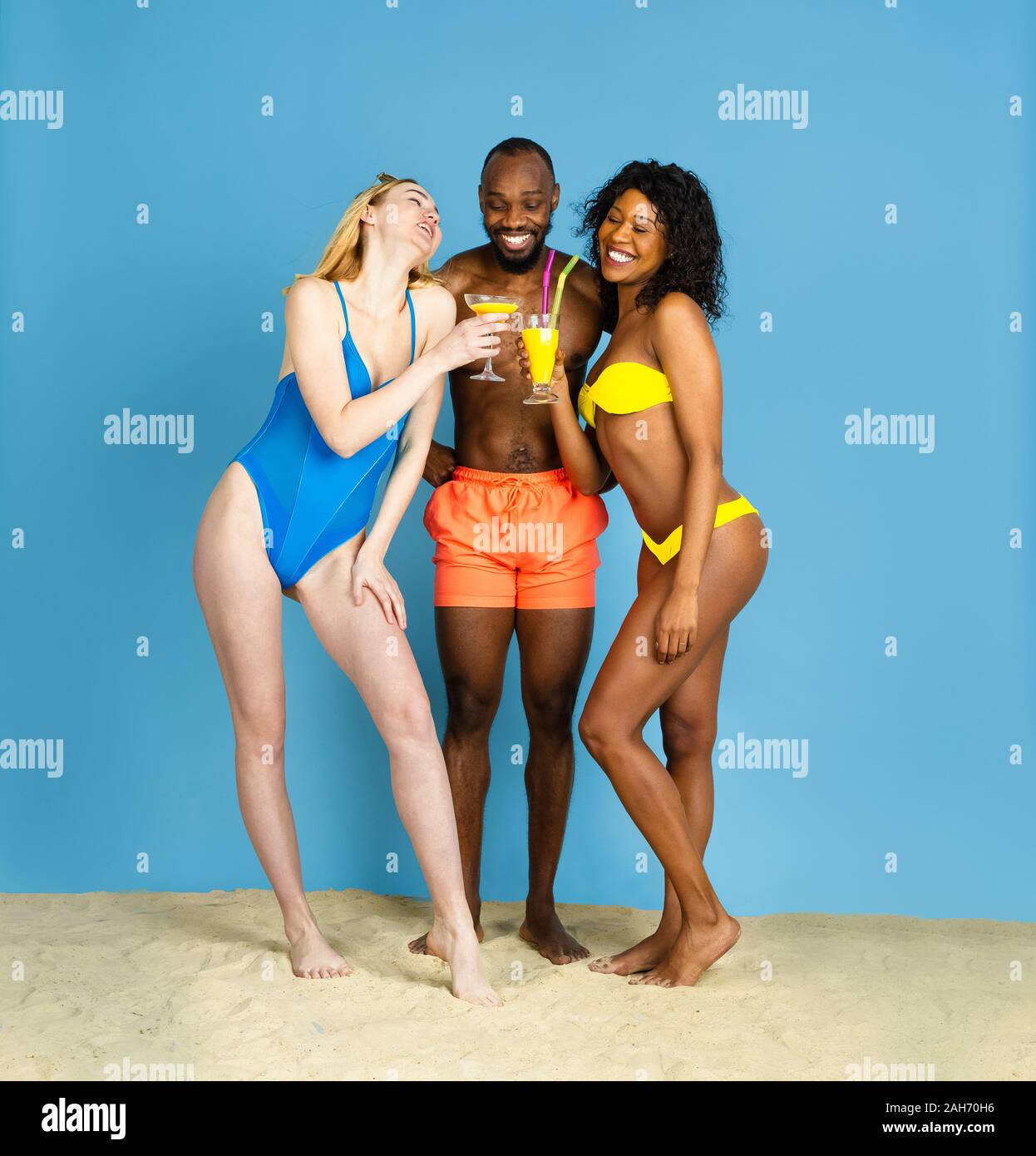 Des moments heureux. Heureux les jeunes amis se reposer et s'amuser sur fond studio bleu. Concept d'émotions humaines, expression du visage, vacances d'été ou de fin de semaine. Chill, été, mer, océan. Banque D'Images